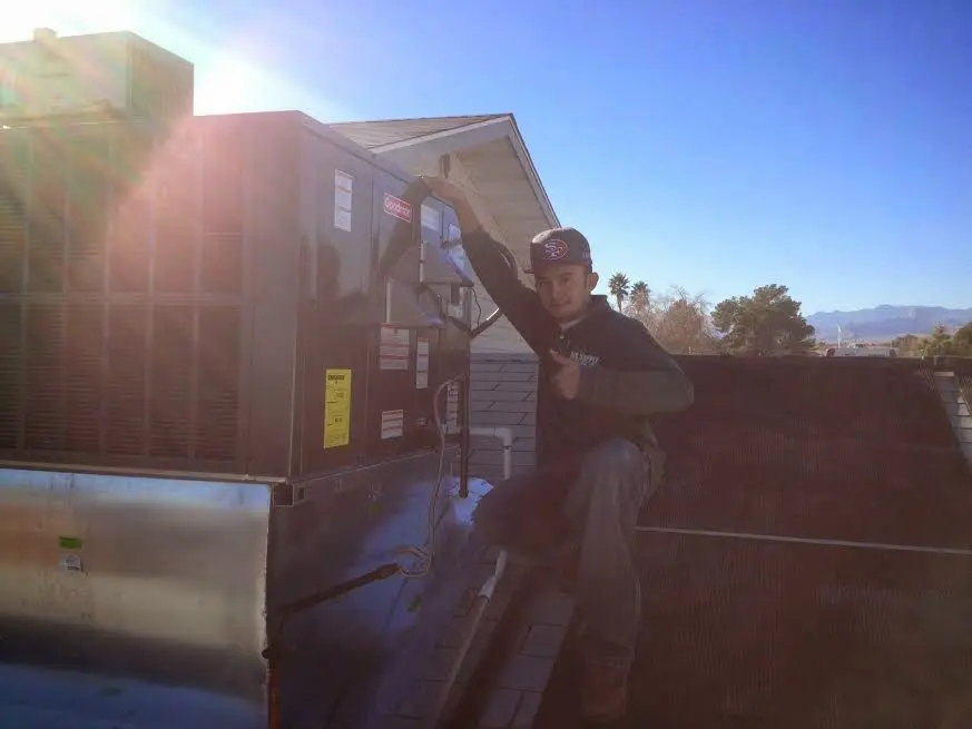 HVAC technician performing AC Tune-Up on a rooftop unit in Bay Village
